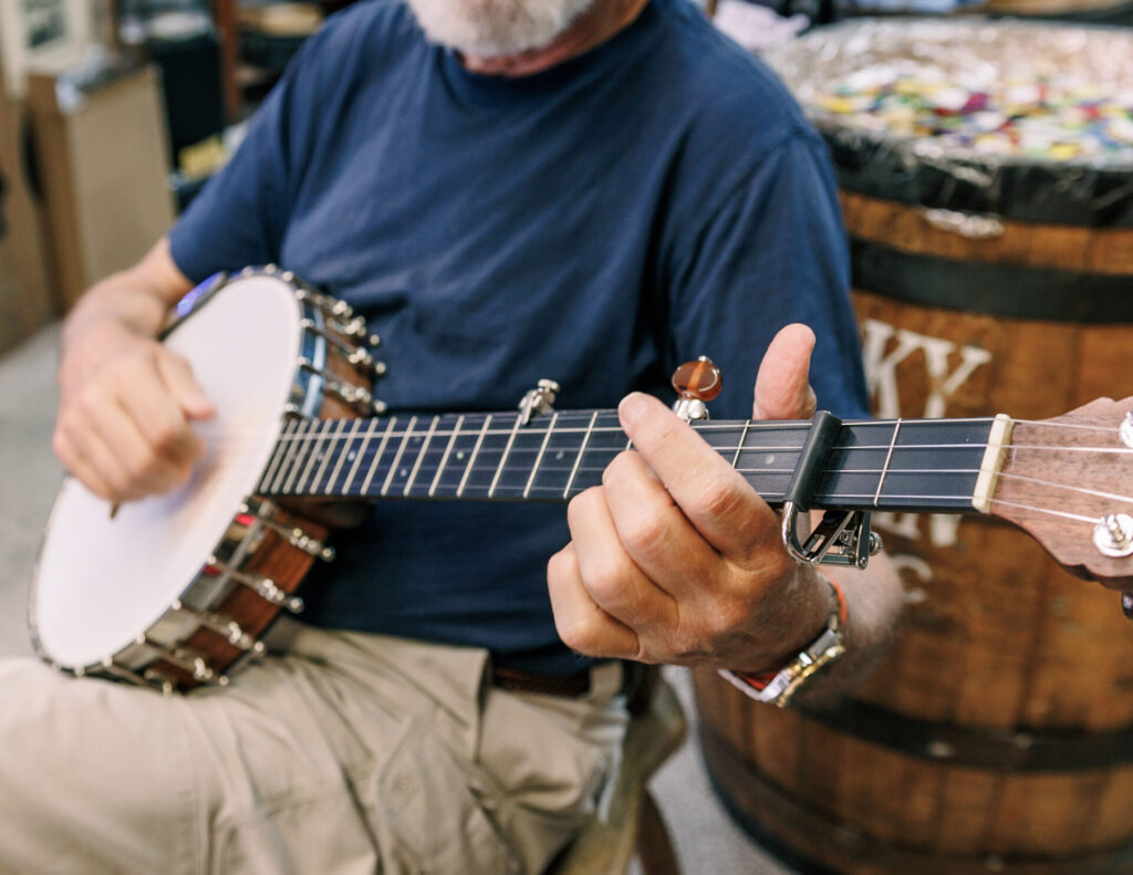 Musician playing a banjo in clawhammer style at a Galax venue.