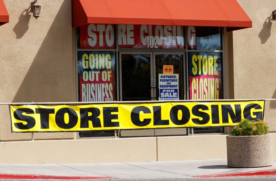 Storefront with large “Store Closing” and “Going Out of Business” signs in the windows.